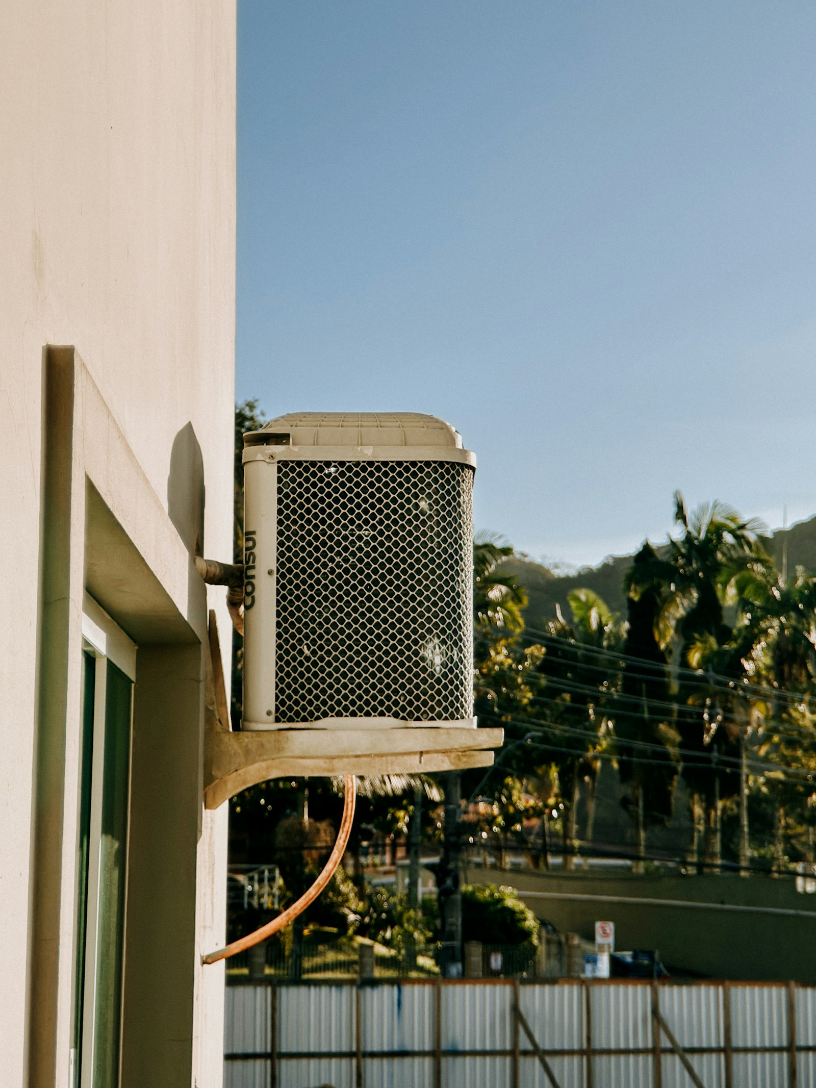 Outdoor mini-split condenser mounted on a building wall